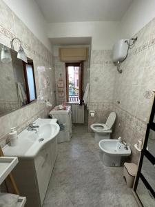 a bathroom with two sinks and a toilet and a mirror at Casa vacanze Soleluna in Agropoli