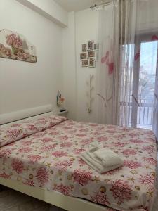 a bedroom with a bed with a pink floral bedspread at Casa vacanze Soleluna in Agropoli +21 photos