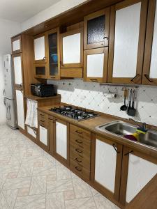 a kitchen with wooden cabinets and a stainless steel sink at Casa vacanze Soleluna in Agropoli