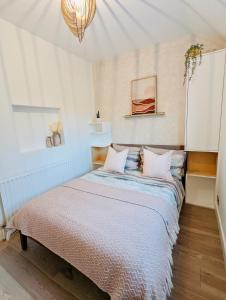 a bedroom with a bed in a white room at Trafalgar House Apartment in Beckenham