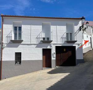 a white building with two doors and two balconies at Apartamento Victoria A in Fuente Obejuna