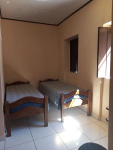 1 Schlafzimmer mit 2 Betten und einem Fenster in der Unterkunft Pousada Tio Sinhô e Tia Sinhá in Rio de Contas