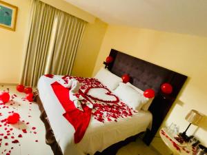 una camera con letto ricoperto di decorazioni rosse di Hotel Martell a San Pedro Sula