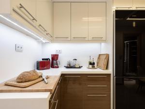 a kitchen with white cabinets and a cutting board on a counter at Villa Moroni in Morónion