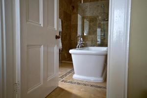 y baño con bañera blanca y lavamanos. en Loch Gorm House, en Bruichladdich 37 fotos más