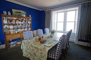 comedor con mesa, sillas y ventana en Loch Gorm House, en Bruichladdich