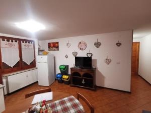 a living room with a table and a refrigerator at Casa Cuore in Sassello
