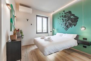 - une chambre avec un grand lit blanc et un mur vert dans l'établissement Easylife - Chic e moderno bilocale con balconcino sul Naviglio grande, à Milan