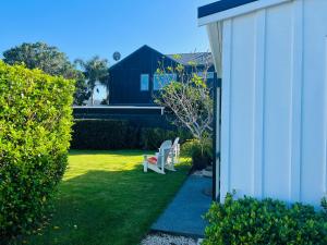 eine weiße Bank auf einem Hof neben einem Gebäude in der Unterkunft The Cottage at 95a - self contained, quiet and peaceful in Big Omaha