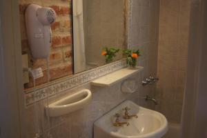 a bathroom with a sink and a mirror at Lorelei in Mina Clavero