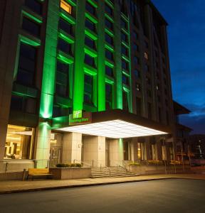 Un bâtiment avec des lumières vertes sur son côté dans l'établissement Holiday Inn - Kyiv, an IHG Hotel, à Kiev