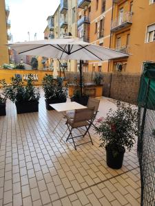 een tafel en stoel met een parasol op een patio bij Ak holidays apartments 81 in Bologna