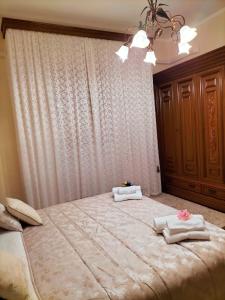 - une chambre avec un grand lit et des serviettes dans l'établissement B&B Rosa dei Venti, à Sorso