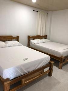2 Betten in einem Zimmer mit weißer Bettwäsche in der Unterkunft Edificio Itzé SOLARIS apto 2 habitaciones in Tolú