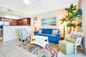 a living room with a blue couch and chairs at Waterscape B624 in Fort Walton Beach