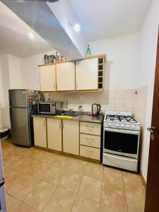 a kitchen with a stove and a refrigerator at Jujuy Downtown suite WIIFI in San Salvador de Jujuy