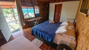 a bedroom with a bed and a view of the ocean at Casa Janjão in Icaraí