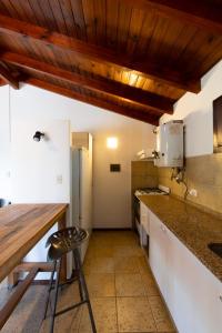 cocina con armarios blancos y techo de madera en Villa Sol en Córdoba