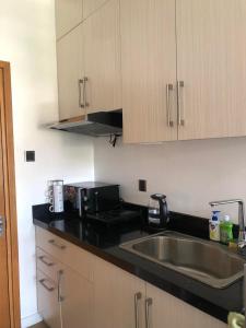 a kitchen with a sink and a microwave at Antara Residential Condominium in Talisay