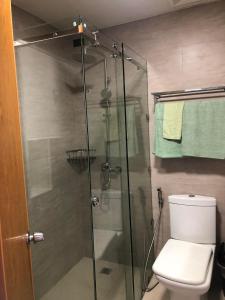 a bathroom with a glass shower with a toilet at Antara Residential Condominium in Talisay