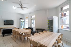 une salle à manger avec deux tables et une télévision dans l'établissement Tequila Sunrise Hostel Sydney, à Sydney