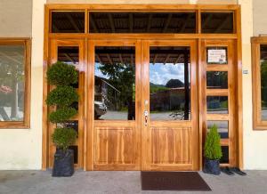 a wooden door of a building with two potted plants at La Casa De Eros in Ayampe +6 photos