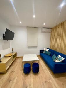 ein Wohnzimmer mit einem blauen Sofa und einem Tisch in der Unterkunft Apartamento boutique Jaén 2 in Jaén