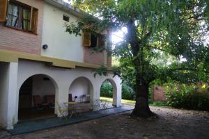 a house with a tree and a table and chairs at Lorelei in Mina Clavero
