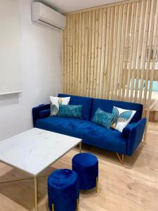 ein Wohnzimmer mit einem blauen Sofa und blauen Hockern in der Unterkunft Apartamento boutique Jaén 2 in Jaén