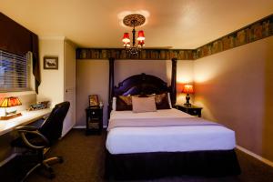 a bedroom with a bed and a desk and a chair at Strawberry Valley Inn in Mount Shasta