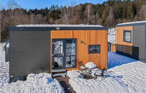 un bâtiment dans la neige avec une table dans l'établissement Wildkraeuterweg 1, à Gottsdorf