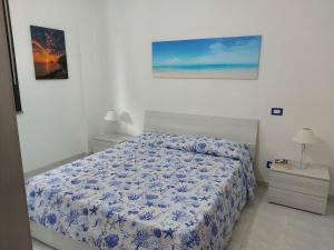 a bedroom with a bed and a painting on the wall at Casa Alghero Lido in Alghero