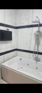 La salle de bains est pourvue d'une baignoire blanche et d'un lavabo. dans l'établissement مدينه نصر مكرم عبيد, au Caire