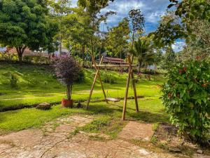 a park with a wooden swing and a tree at Espaço Monjolo in Barra do Garças
