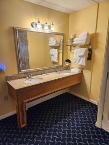 La salle de bains est pourvue d'un lavabo et d'un grand miroir. dans l'établissement Best Western White House Inn, à Bangor