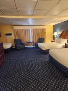 um quarto de hotel com duas camas, uma secretária e cadeiras em Best Western White House Inn em Bangor
