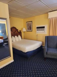 a hotel room with a bed and a chair at Best Western White House Inn in Bangor