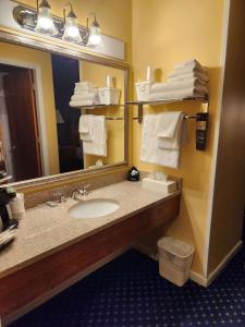 a bathroom with a sink and a mirror and towels at Best Western White House Inn in Bangor
