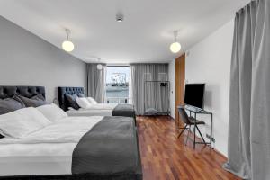a hotel room with two beds and a television at Studio Apartment with Ocean View in Reykjavík
