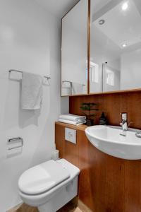 a bathroom with a white toilet and a sink at Studio Apartment with Ocean View in Reykjavík