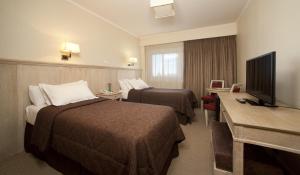 a hotel room with two beds and a flat screen tv at Hotel Patagonia in Río Gallegos +42 photos