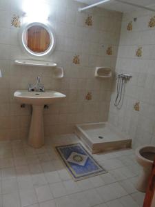 uma casa de banho com um lavatório, um chuveiro e um WC. em Paradise Inn em Milatos