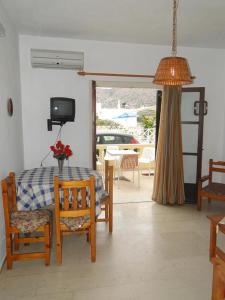 uma sala de estar com uma mesa e cadeiras e uma televisão em Paradise Inn em Milatos
