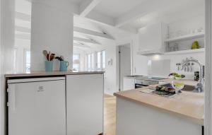 a white kitchen with a counter and a sink at Holiday Home Ringkobing Xli in Søndervig