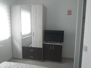a bedroom with a tv and a mirror at Bellacasa in Zalău