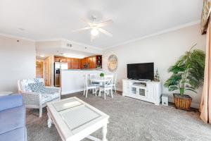a living room with a television and a table at Waterscape B628 in Fort Walton Beach