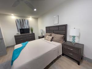 a bedroom with a large white bed and a dresser at Modern Santorini Suite Houston NRG TMC Luxurious Walkable in Houston