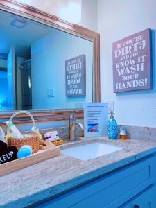 um balcão de casa de banho com um lavatório e um espelho em Modern Santorini Suite Houston NRG TMC Luxurious Walkable em Houston