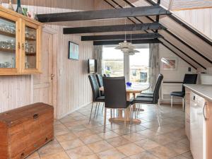 een keuken en eetkamer met een tafel en stoelen bij 8 person holiday home in Ringk bing in Nørre Lyngvig