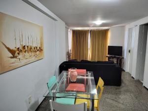 a living room with a glass table and a couch at Iracema Vista sensacional 4 pessoas in Fortaleza